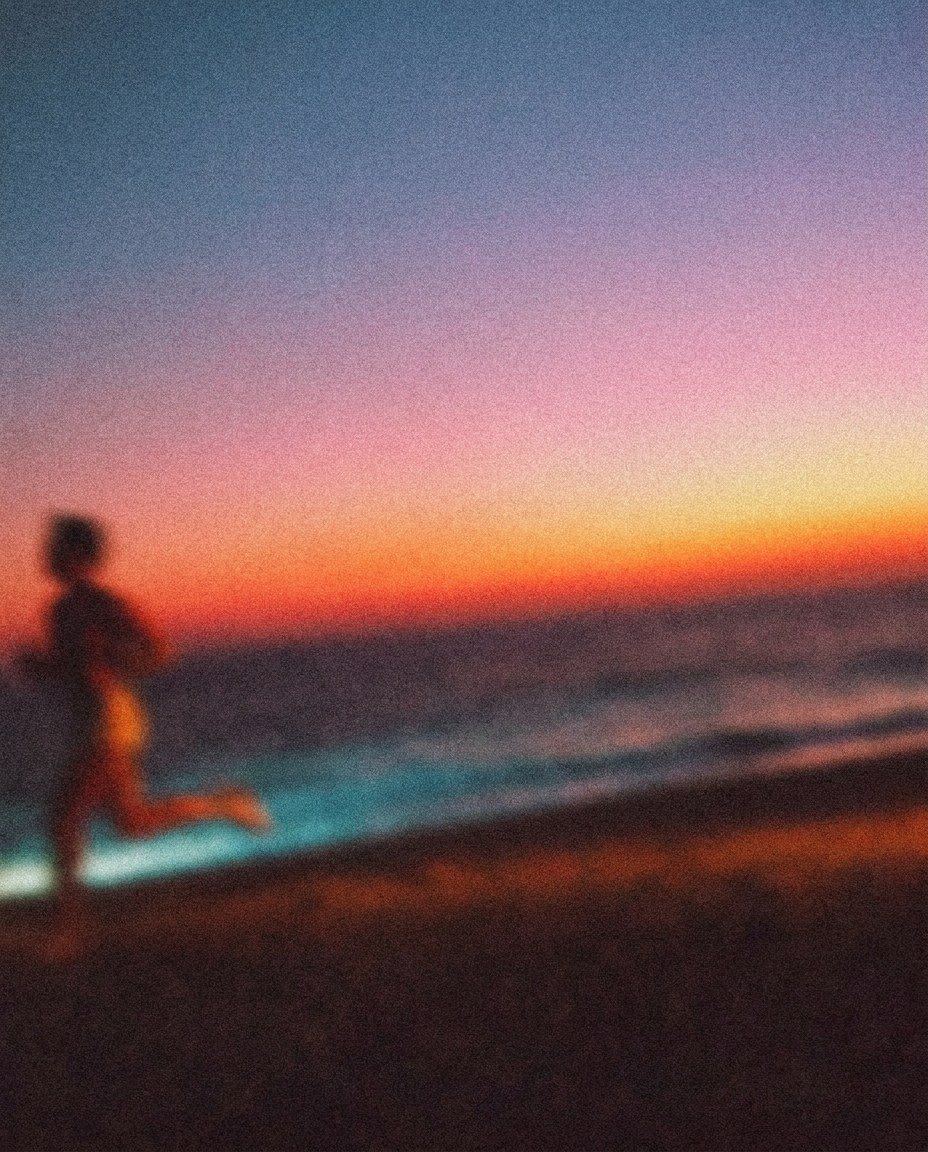 Unscharfe Läuferin am Strand im Abendlicht